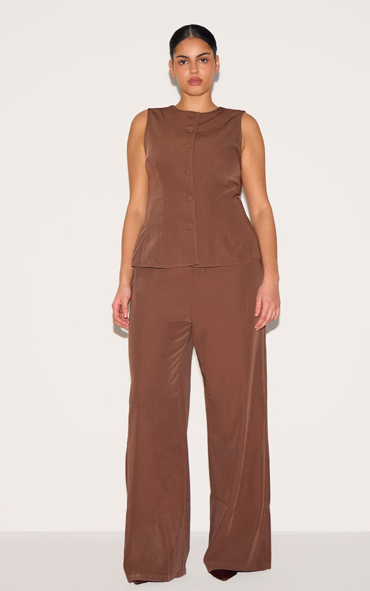 https://cdn-img.prettylittlething.com/2/c/6/9/2c694f2db64848fd96c4c94d04bd1e3a0214032c_CNL8284_1_plus_chocolate_brown_high_neck_waistcoat_straight_leg_jumpsuit.jpg